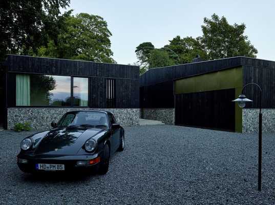 Horizontal House Composed of Three Volumes Surrounded by Dense Vegetation