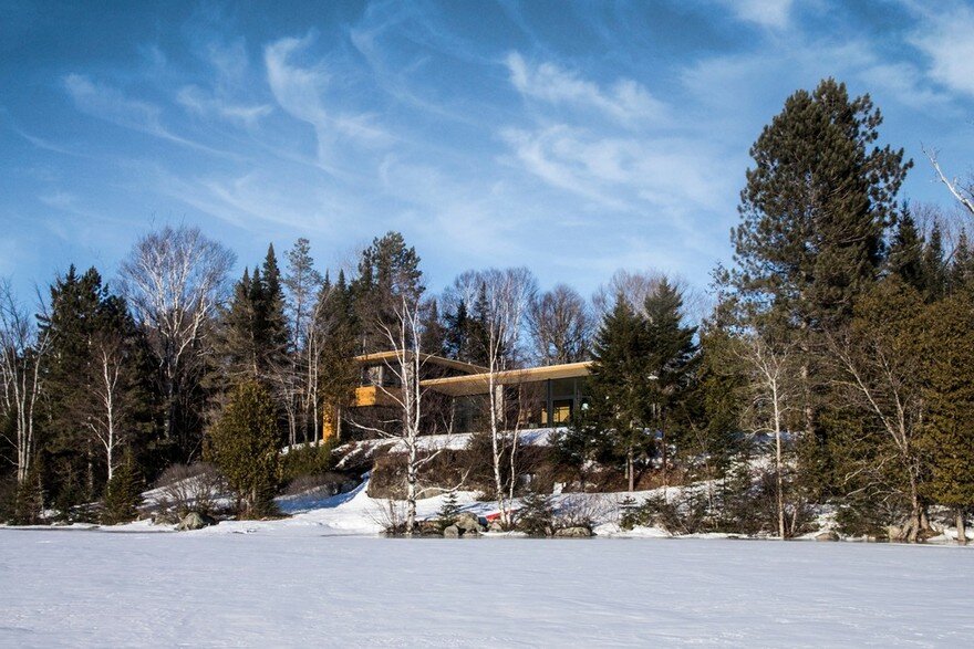 Wooden Wing Cottage in Quebec Perched on a Granite Bedrock